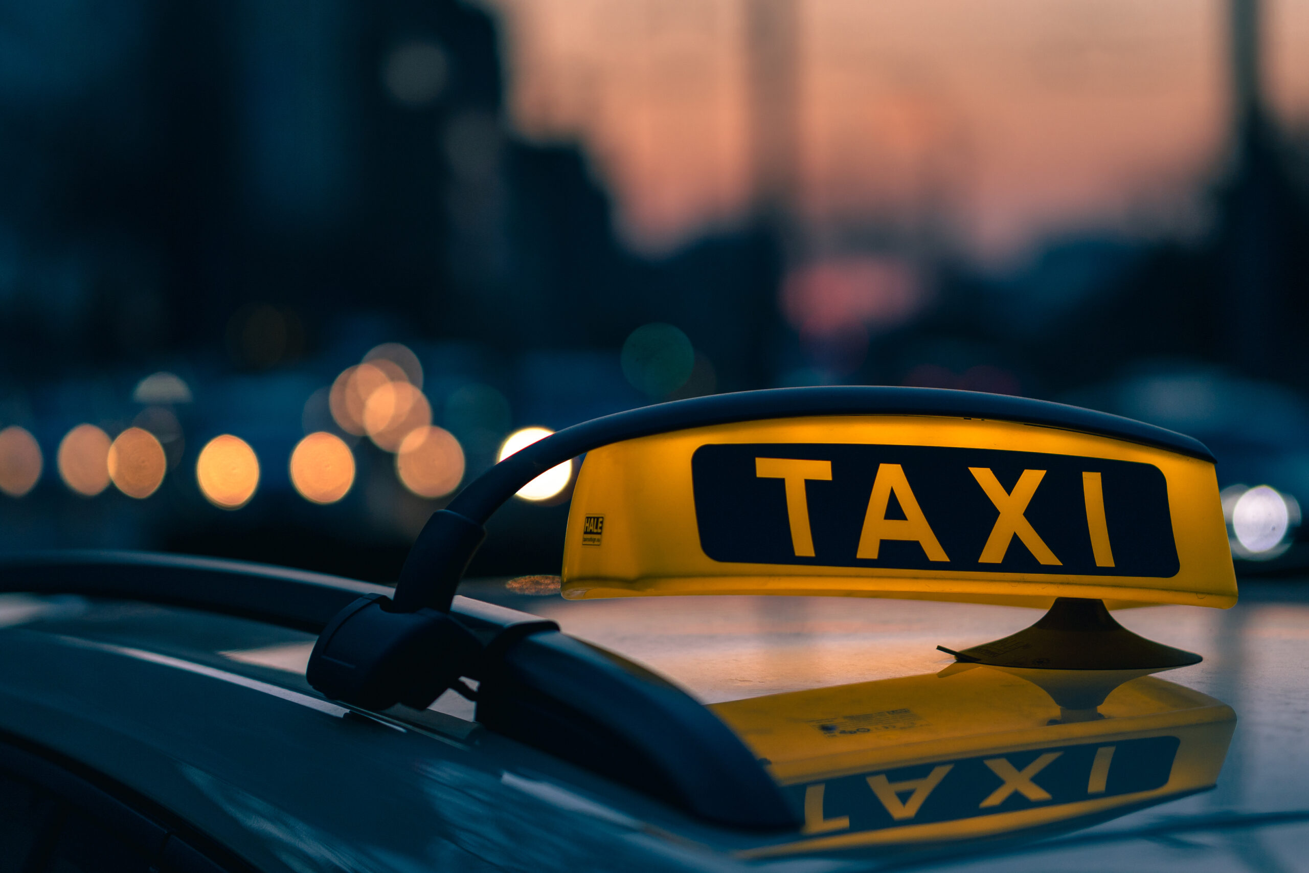Services Close Up Shot Taxi Sign Warm Colours Sunset With Bokeh Lights Background Scaled